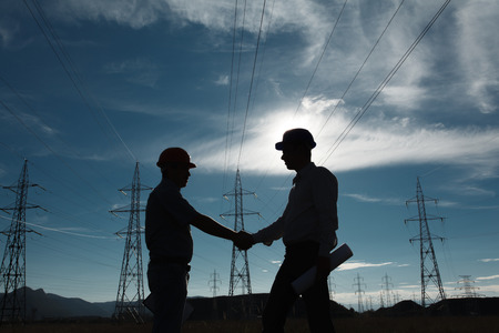33008357-silueta-de-dos-ingenieros-de-pie-en-la-estación-de-energía-eléctrica-en-el-ocaso